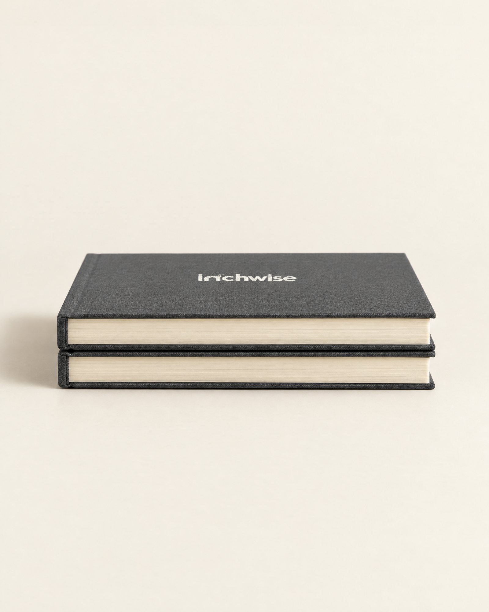 Two Inchwise journals stacked, showing the cream page edges